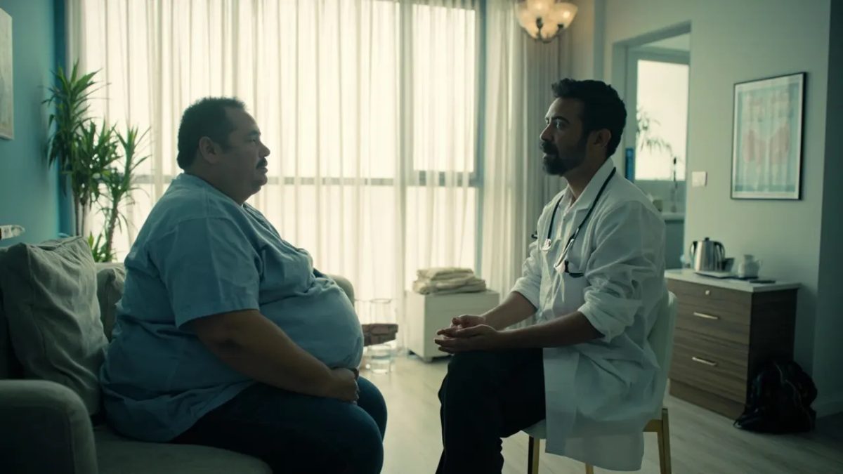 Consulta médica en una clínica luminosa con luz de mañana, un profesional sanitario conversa de forma empática con una paciente adulta de cuerpo diverso en un ambiente de confianza y respeto